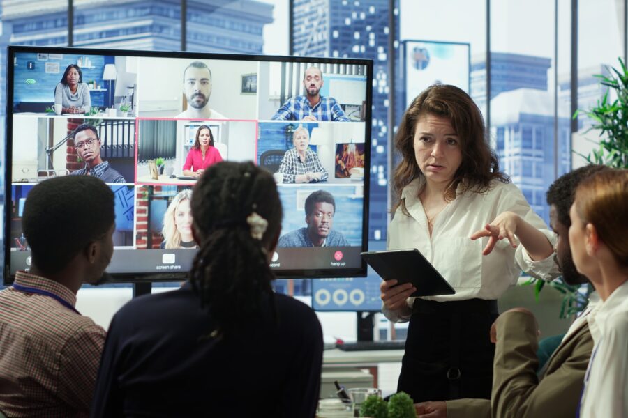 Business team in a boardroom attend videocall meeting with investors group, discussing about increasing funds for a global development plan. Staff and shareholders on teleconference. Camera A.