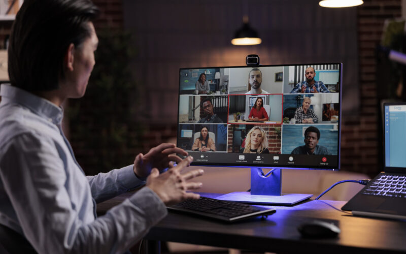 Office worker using videocall conference to meet with business people on webcam, talking to colleagues on remote videoconference. Having internet conversation on teleconference call.